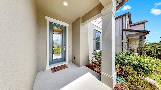 9293 Rally Spring Loop, Wesley Chapel, FL 33545 - doorway to property with stucco siding and a porch