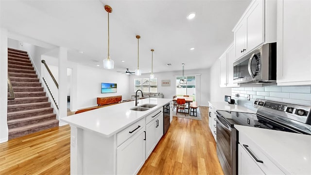9293 Rally Spring Loop, Wesley Chapel, FL 33545 - kitchen featuring stainless steel appliances, a sink, light wood-type flooring, a center island with sink, and recessed lighting