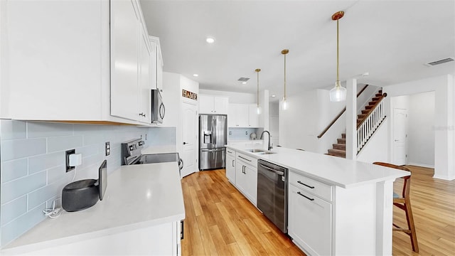 9293 Rally Spring Loop, Wesley Chapel, FL 33545 - kitchen featuring appliances with stainless steel finishes, a sink, a breakfast bar area, decorative backsplash, and white cabinets