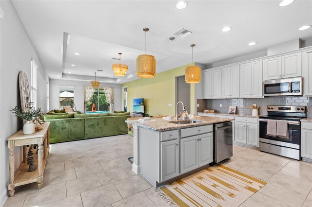 30801 Parrot Reef Ct, Wesley Chapel, FL 33545 - kitchen with stainless steel appliances, a sink, backsplash, recessed lighting, and open floor plan