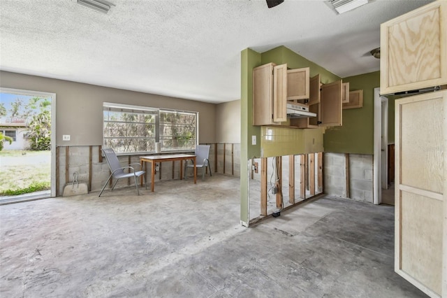 123 14th Ave, Indian Rocks Beach, FL 33785 - kitchen with light brown cabinets, concrete floors, under cabinet range hood, and a textured ceiling