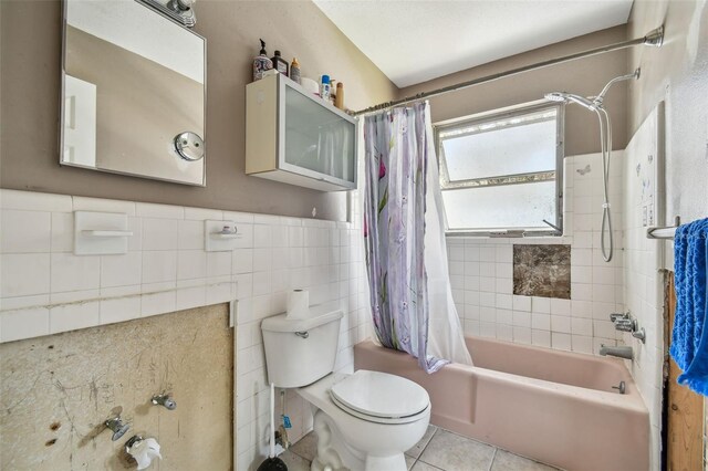 123 14th Ave, Indian Rocks Beach, FL 33785 - bathroom featuring shower / tub combo, tile walls, toilet, tile patterned floors, and a wainscoted wall
