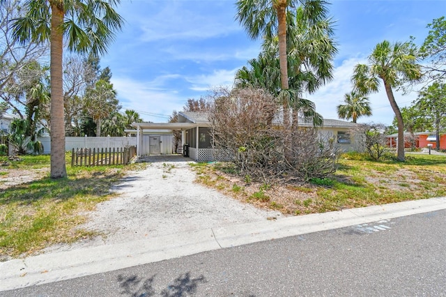 123 14th Ave, Indian Rocks Beach, FL 33785 - obstructed view of property with dirt driveway and an attached carport