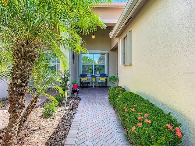 15860 Aurora Lake Cir, Wimauma, FL 33598 - view of exterior entry with stucco siding and a patio area