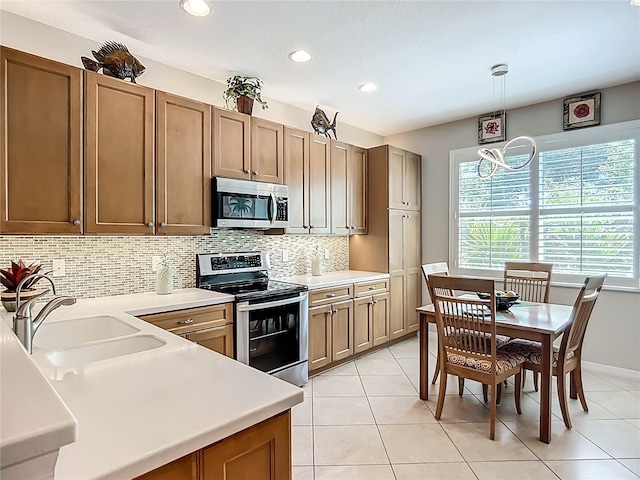 15860 Aurora Lake Cir, Wimauma, FL 33598 - kitchen with stainless steel appliances, a sink, backsplash, hanging light fixtures, and light countertops