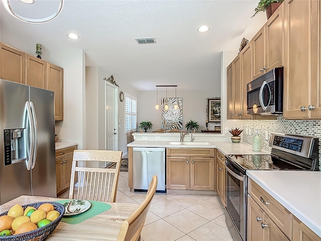 15860 Aurora Lake Cir, Wimauma, FL 33598 - kitchen with appliances with stainless steel finishes, a sink, light tile patterned floors, light countertops, and a peninsula