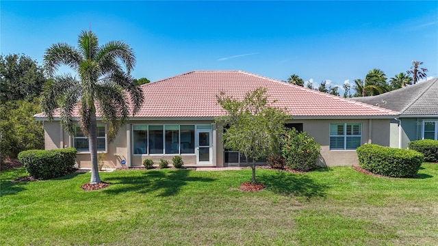15860 Aurora Lake Cir, Wimauma, FL 33598 - back of house with stucco siding, a tiled roof, and a lawn