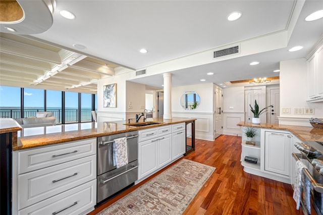 7600 Bayshore Dr Unit 1201A, Treasure Island, FL 33706 - kitchen featuring a sink, stainless steel appliances, ornate columns, white cabinetry, and a peninsula