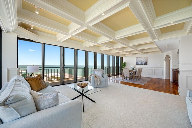 7600 Bayshore Dr Unit 1201A, Treasure Island, FL 33706 - living area featuring arched walkways, coffered ceiling, beam ceiling, wood finished floors, and a water view