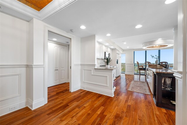 7600 Bayshore Dr Unit 1201A, Treasure Island, FL 33706 - hallway featuring a decorative wall, wood finished floors, recessed lighting, and a wainscoted wall