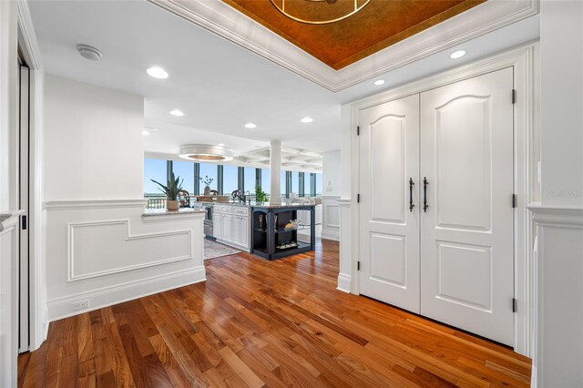 7600 Bayshore Dr Unit 1201A, Treasure Island, FL 33706 - foyer with a decorative wall, wood finished floors, a wainscoted wall, recessed lighting, and a tray ceiling