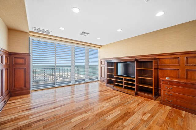 7600 Bayshore Dr Unit 1201A, Treasure Island, FL 33706 - unfurnished living room with light wood finished floors, recessed lighting, a wainscoted wall, and a decorative wall