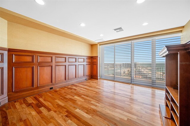 7600 Bayshore Dr Unit 1201A, Treasure Island, FL 33706 - unfurnished room with a decorative wall, recessed lighting, light wood-style floors, and a wainscoted wall