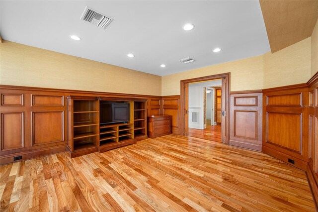 7600 Bayshore Dr Unit 1201A, Treasure Island, FL 33706 - unfurnished living room with light wood-style floors, recessed lighting, a wainscoted wall, and a decorative wall