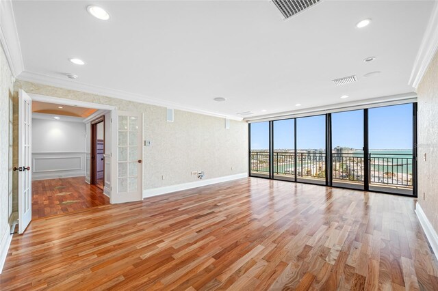 7600 Bayshore Dr Unit 1201A, Treasure Island, FL 33706 - empty room featuring crown molding, light wood-style flooring, and baseboards