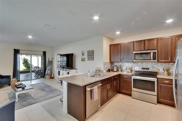 1398 Crescent Hoop Way, Wesley Chapel, FL 33543 - kitchen with stainless steel appliances, a sink, open floor plan, decorative backsplash, and recessed lighting