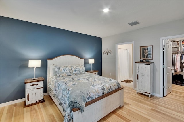 1398 Crescent Hoop Way, Wesley Chapel, FL 33543 - bedroom featuring a walk in closet, wood finished floors, baseboards, and a closet