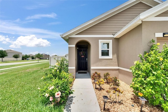 1398 Crescent Hoop Way, Wesley Chapel, FL 33543 - view of exterior entry featuring stucco siding and a lawn