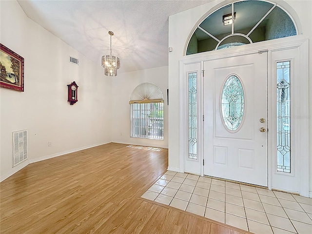 2973 Spring Oak Ct, Palm Harbor, FL 34684 - entrance foyer featuring light wood finished floors, a chandelier, vaulted ceiling, and baseboards