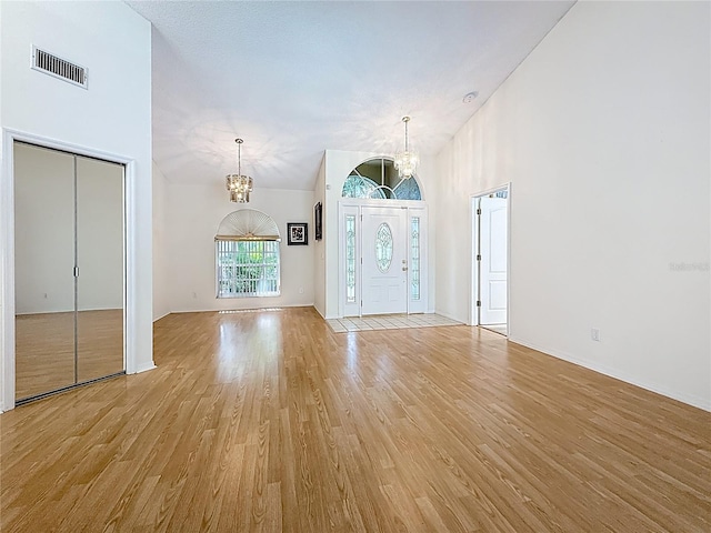 2973 Spring Oak Ct, Palm Harbor, FL 34684 - entrance foyer featuring a chandelier, light wood-style flooring, a high ceiling, and baseboards