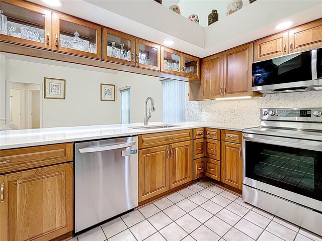 2973 Spring Oak Ct, Palm Harbor, FL 34684 - kitchen featuring appliances with stainless steel finishes, a sink, light countertops, brown cabinets, and light tile patterned floors