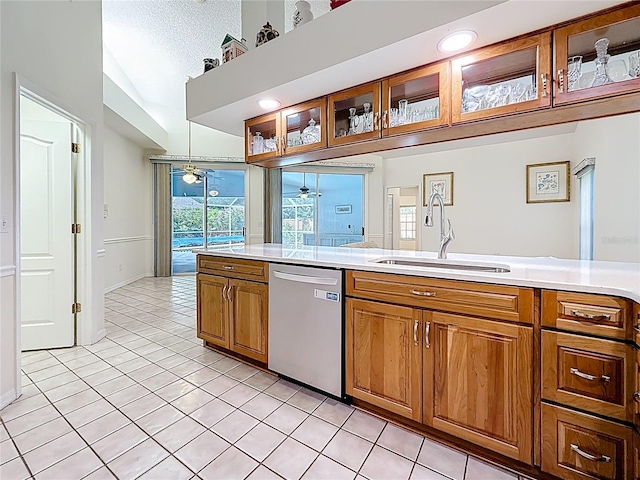 2973 Spring Oak Ct, Palm Harbor, FL 34684 - kitchen with stainless steel dishwasher, a sink, brown cabinets, light tile patterned floors, and light countertops