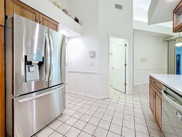 2973 Spring Oak Ct, Palm Harbor, FL 34684 - kitchen with appliances with stainless steel finishes, brown cabinets, light tile patterned flooring, light countertops, and baseboards