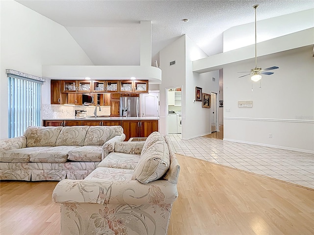 2973 Spring Oak Ct, Palm Harbor, FL 34684 - living room featuring high vaulted ceiling, washing machine and clothes dryer, a ceiling fan, and light tile patterned flooring