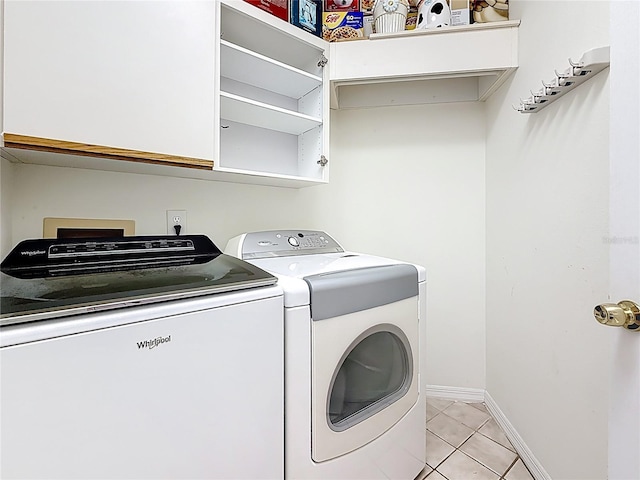 2973 Spring Oak Ct, Palm Harbor, FL 34684 - laundry room featuring separate washer and dryer, light tile patterned flooring, baseboards, and cabinet space