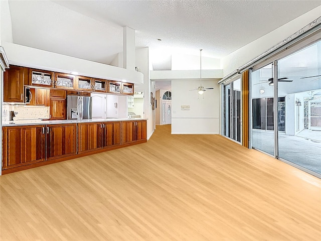 2973 Spring Oak Ct, Palm Harbor, FL 34684 - unfurnished living room featuring ceiling fan, light wood finished floors, a textured ceiling, and high vaulted ceiling