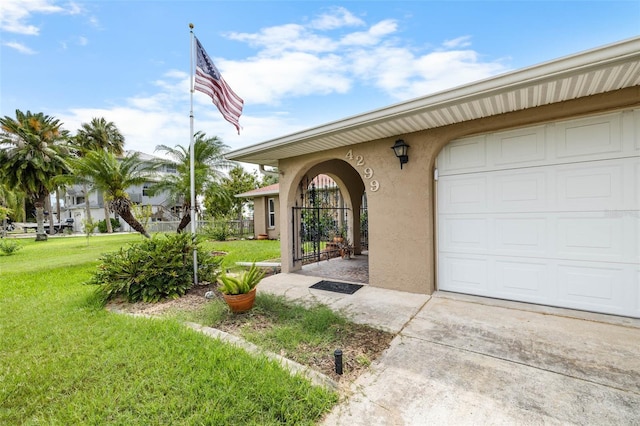 4299 Bellaire Dr, Hernando Beach, FL 34607 - entrance to property featuring stucco siding, a lawn, an attached garage, and driveway