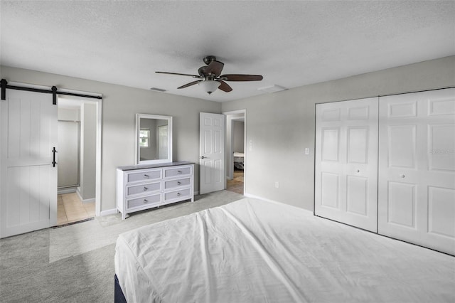 4299 Bellaire Dr, Hernando Beach, FL 34607 - bedroom with a barn door, a textured ceiling, carpet floors, baseboards, and a ceiling fan