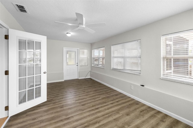 4299 Bellaire Dr, Hernando Beach, FL 34607 - unfurnished room with ceiling fan, baseboards, wood finished floors, and a textured ceiling