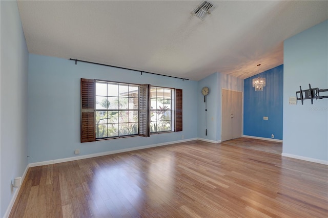 8521 Caitlin Ct, Hudson, FL 34667 - empty room featuring a chandelier, light wood-style floors, and baseboards