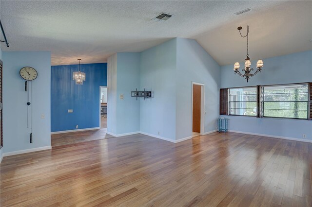 8521 Caitlin Ct, Hudson, FL 34667 - spare room with a chandelier, wood finished floors, lofted ceiling, a textured ceiling, and baseboards
