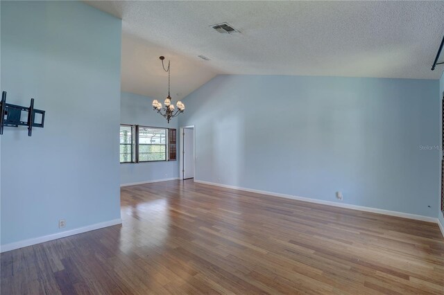 8521 Caitlin Ct, Hudson, FL 34667 - unfurnished room with a chandelier, wood finished floors, baseboards, a textured ceiling, and high vaulted ceiling