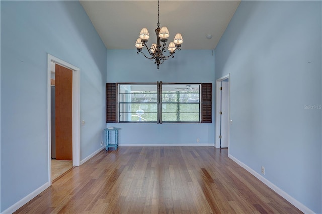 8521 Caitlin Ct, Hudson, FL 34667 - empty room with a chandelier, wood finished floors, and baseboards