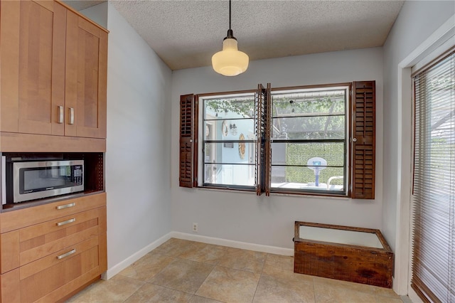8521 Caitlin Ct, Hudson, FL 34667 - unfurnished dining area featuring baseboards, a textured ceiling, and light tile patterned flooring