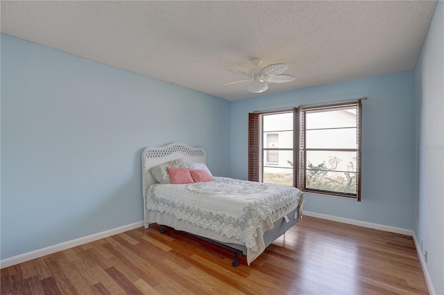 8521 Caitlin Ct, Hudson, FL 34667 - bedroom featuring wood finished floors, baseboards, a textured ceiling, and a ceiling fan