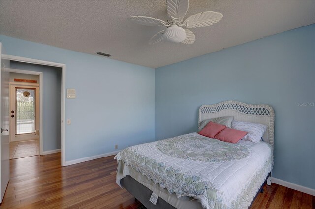 8521 Caitlin Ct, Hudson, FL 34667 - bedroom with wood finished floors, baseboards, ceiling fan, and a textured ceiling