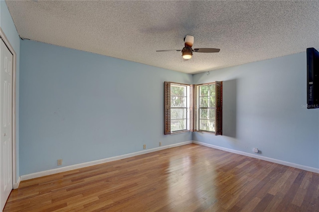 8521 Caitlin Ct, Hudson, FL 34667 - unfurnished bedroom featuring wood finished floors, a textured ceiling, a closet, baseboards, and a ceiling fan