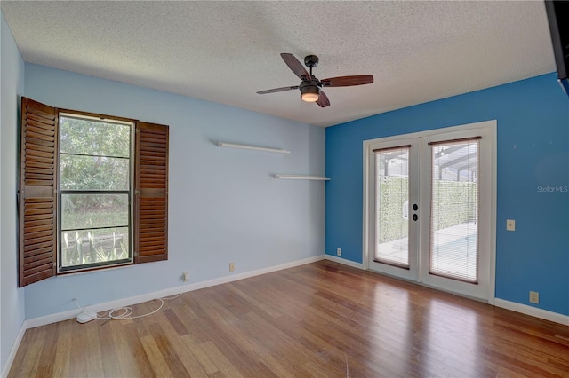 8521 Caitlin Ct, Hudson, FL 34667 - empty room with french doors, plenty of natural light, wood finished floors, and a textured ceiling