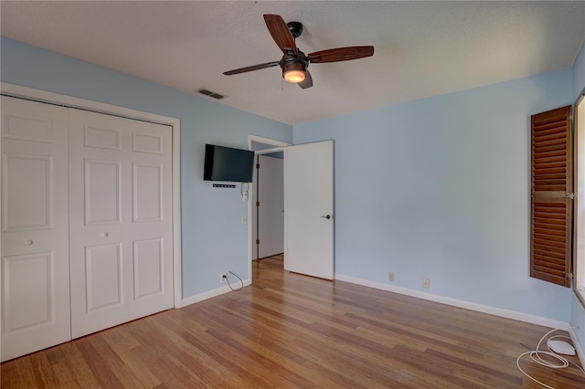 8521 Caitlin Ct, Hudson, FL 34667 - unfurnished bedroom featuring wood finished floors, baseboards, ceiling fan, a textured ceiling, and a closet