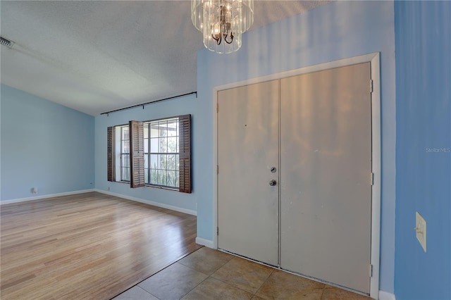 8521 Caitlin Ct, Hudson, FL 34667 - entryway with a chandelier, a textured ceiling, baseboards, and tile patterned flooring