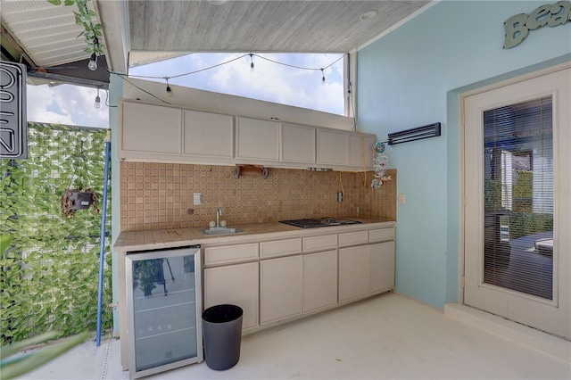 8521 Caitlin Ct, Hudson, FL 34667 - kitchen with wine cooler, backsplash, light countertops, white cabinets, and a sink