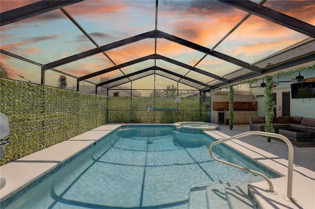 8521 Caitlin Ct, Hudson, FL 34667 - pool at dusk featuring an outdoor living space, a patio, a pool with connected hot tub, and a lanai