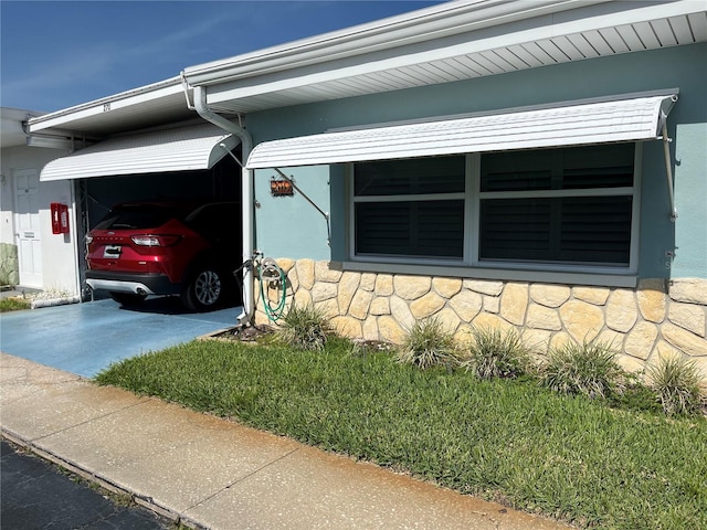 250 Rosery Rd NW Unit 270, Largo, FL 33770 - view of side of home featuring stone siding, driveway, and stucco siding
