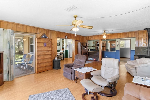 1226 S Telephone Point Rd, Inverness, FL 34450 - living area featuring plenty of natural light, wooden walls, a ceiling fan, and light wood-style floors