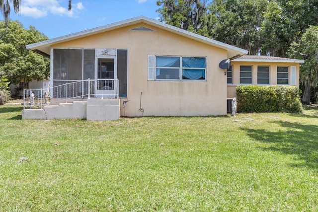 1226 S Telephone Point Rd, Inverness, FL 34450 - view of front facade with stucco siding, a sunroom, and a front yard