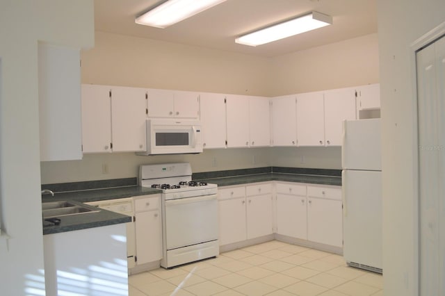 1922 Sassafras Dr, Wesley Chapel, FL 33543 - kitchen featuring white appliances, white cabinets, dark countertops, and a sink